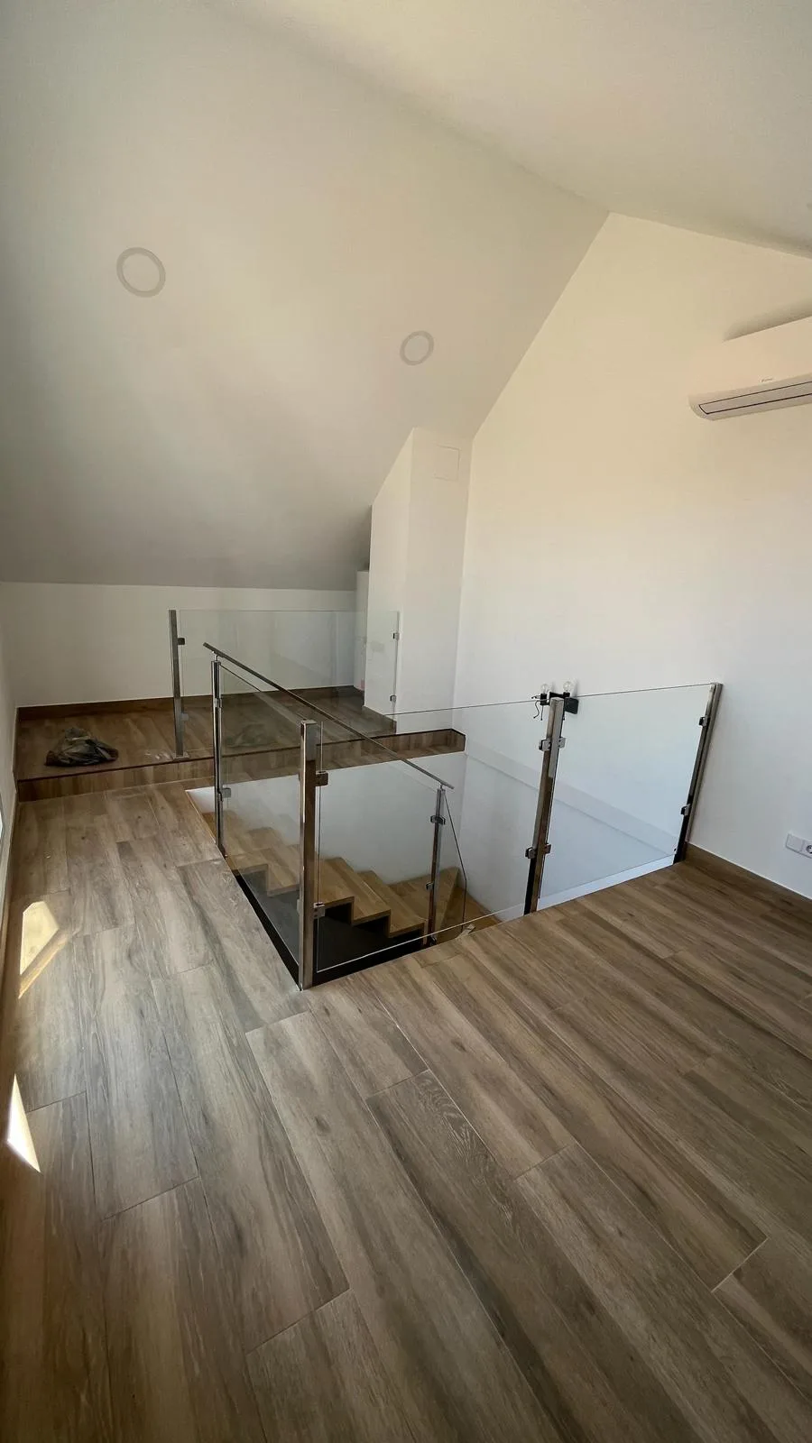 Barandilla de cristal y acero instalada alrededor de una escalera