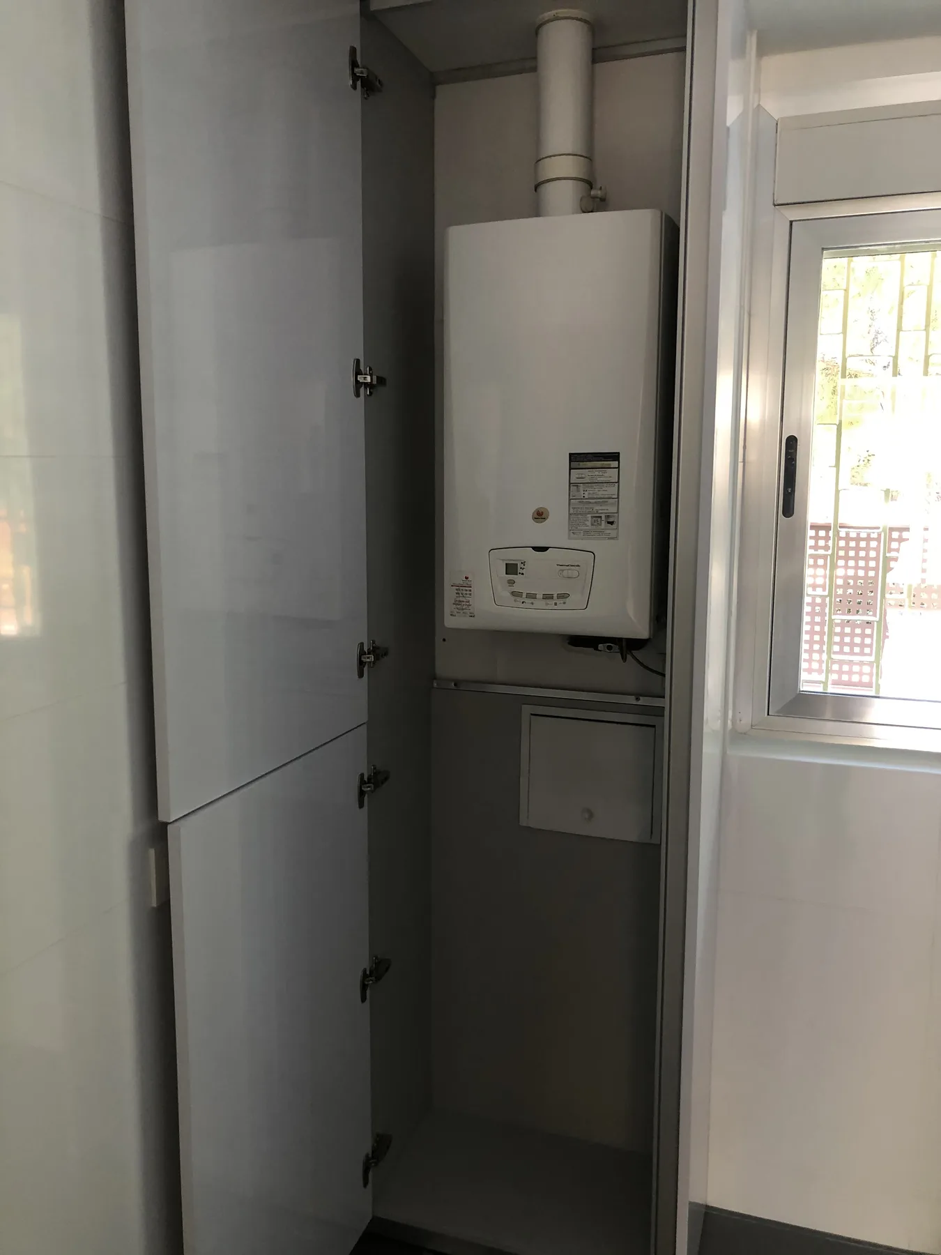 Zona de fregadero en cocina blanca con encimera y frente negros