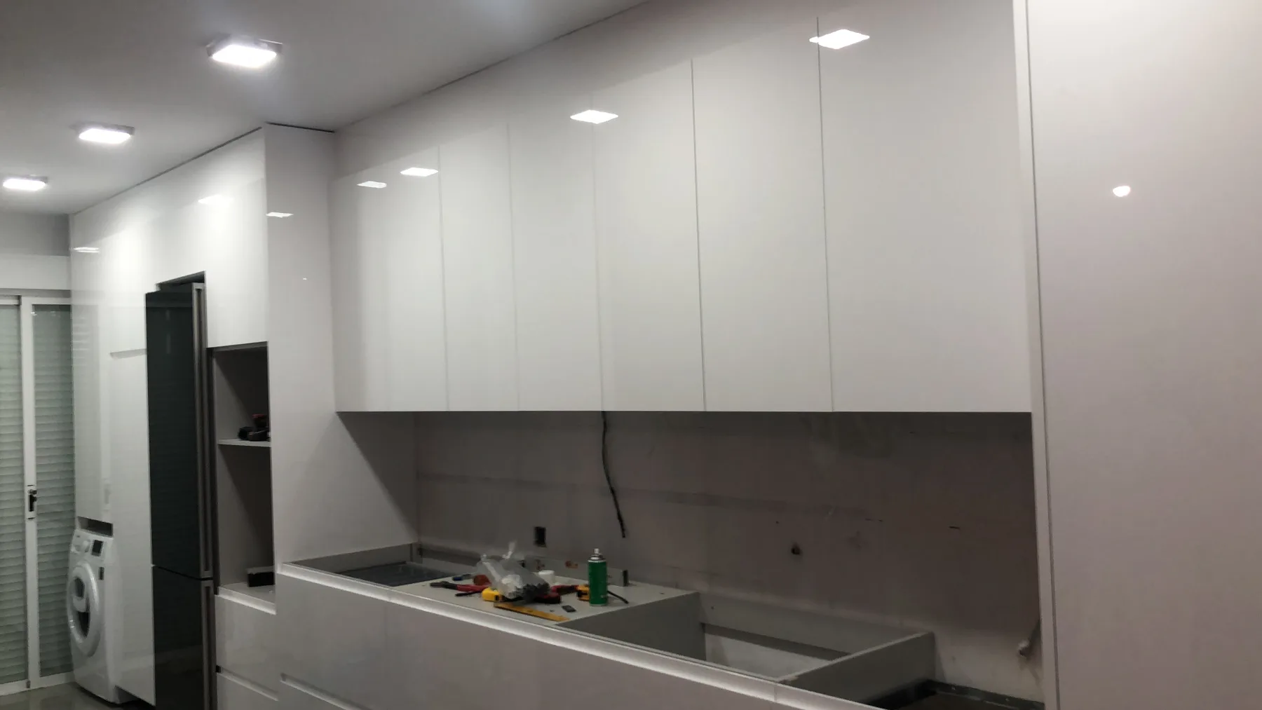 Instalación de cocina lineal con muebles blancos durante la reforma