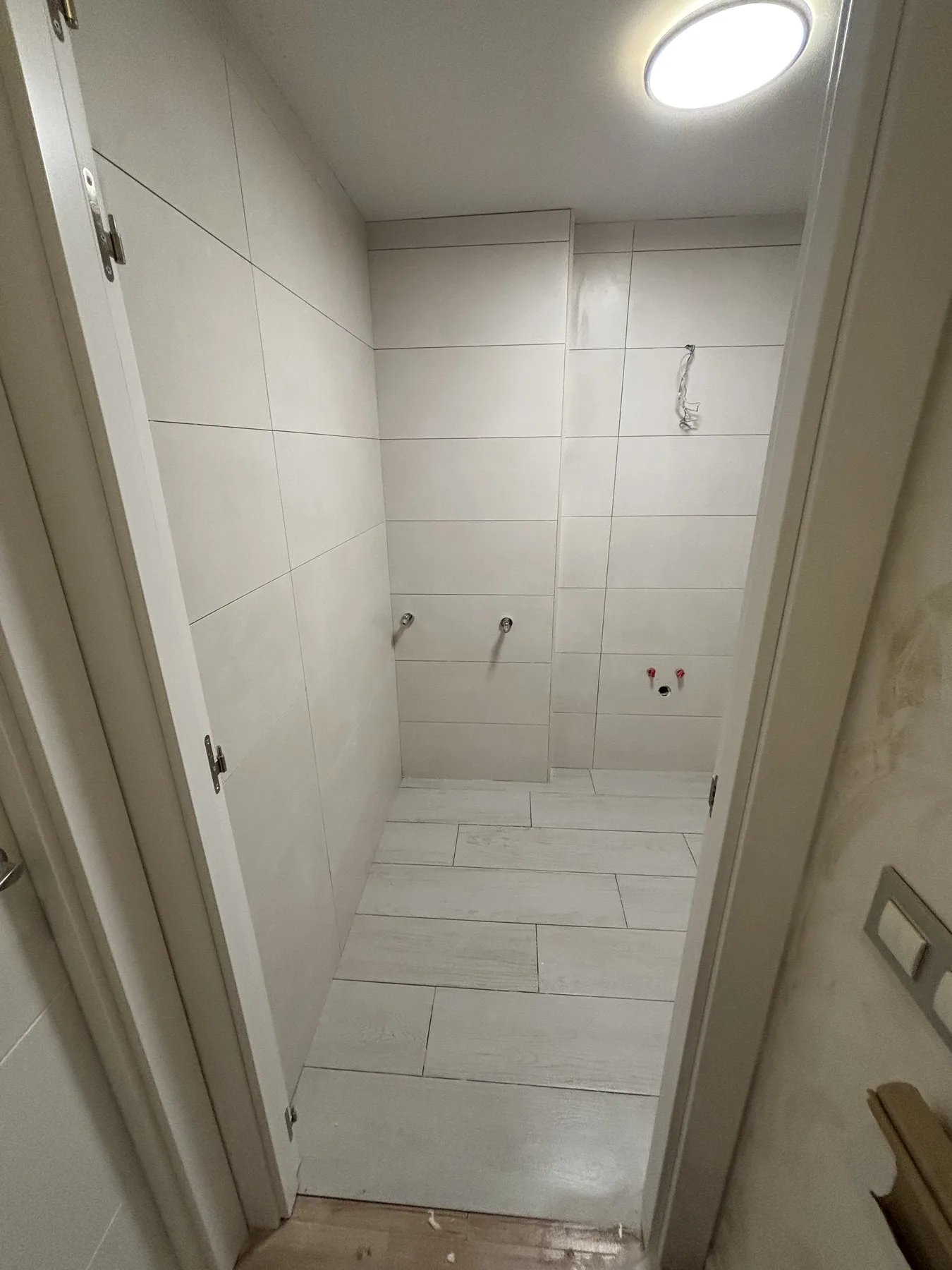 Alicatado blanco de baño con pavimento efecto madera