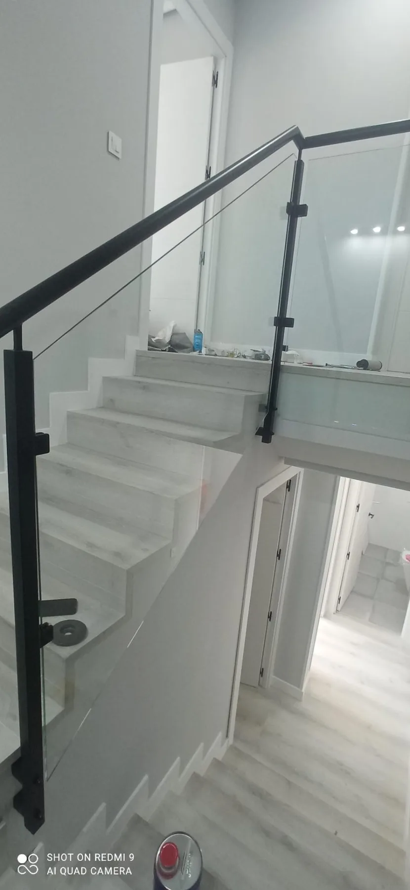 Detalle de barandilla de cristal con estructura metálica negra