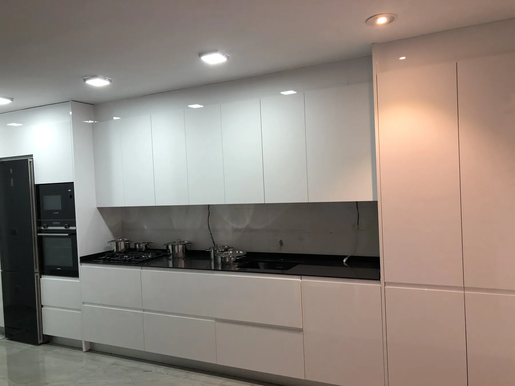 Armario auxiliar integrado junto a la ventana de una cocina reformada