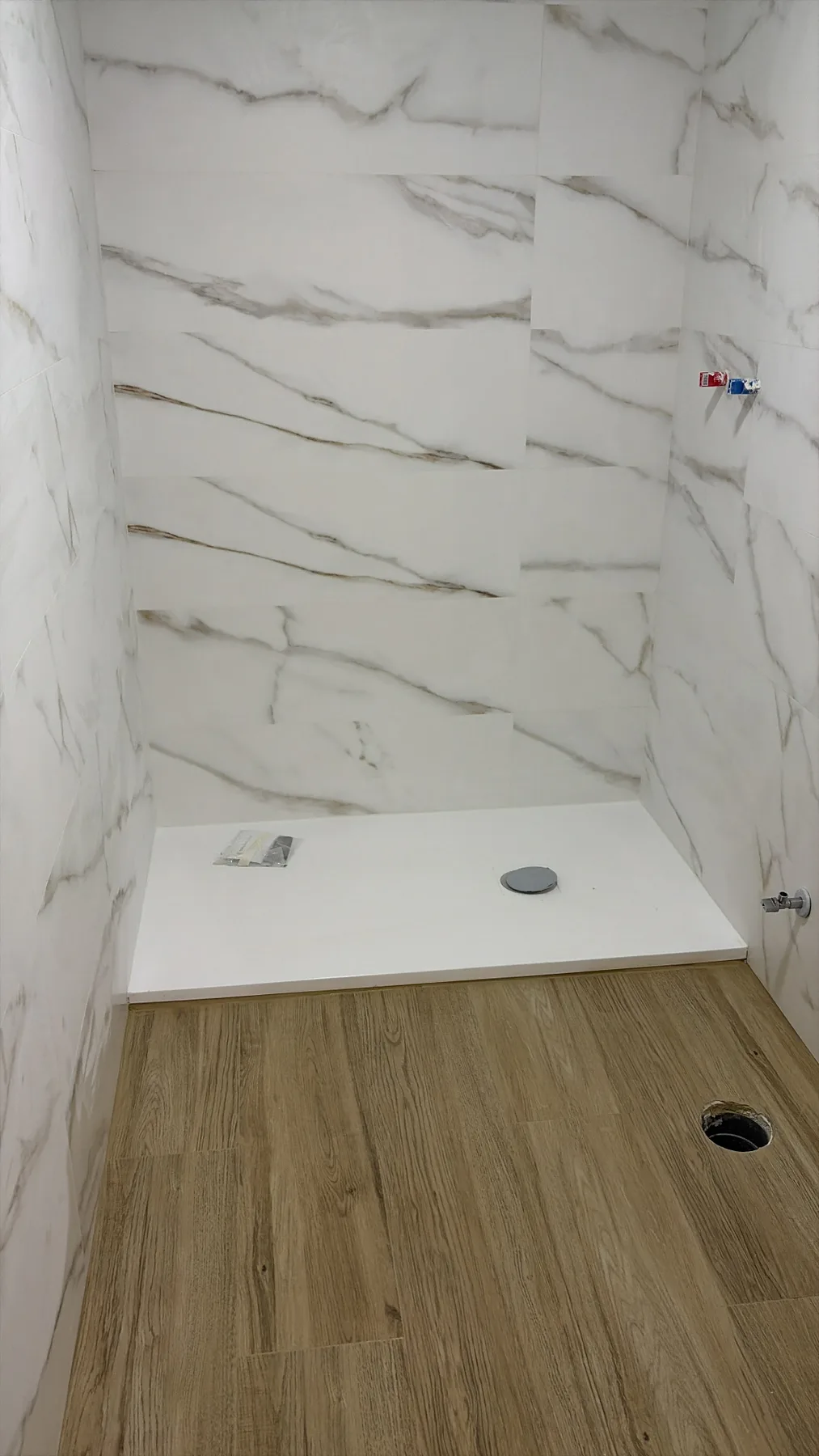 Alicatado de baño con porcelánico efecto mármol y plato de ducha