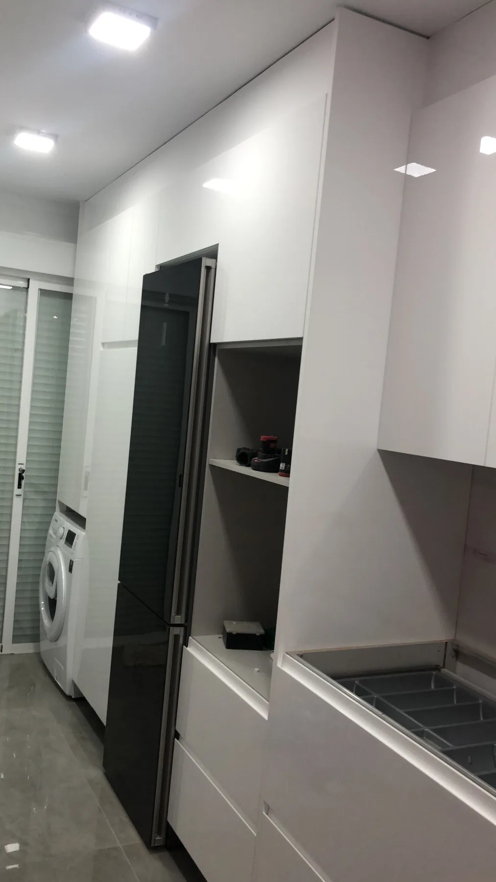 Columna de frigorífico y muebles blancos en cocina reformada