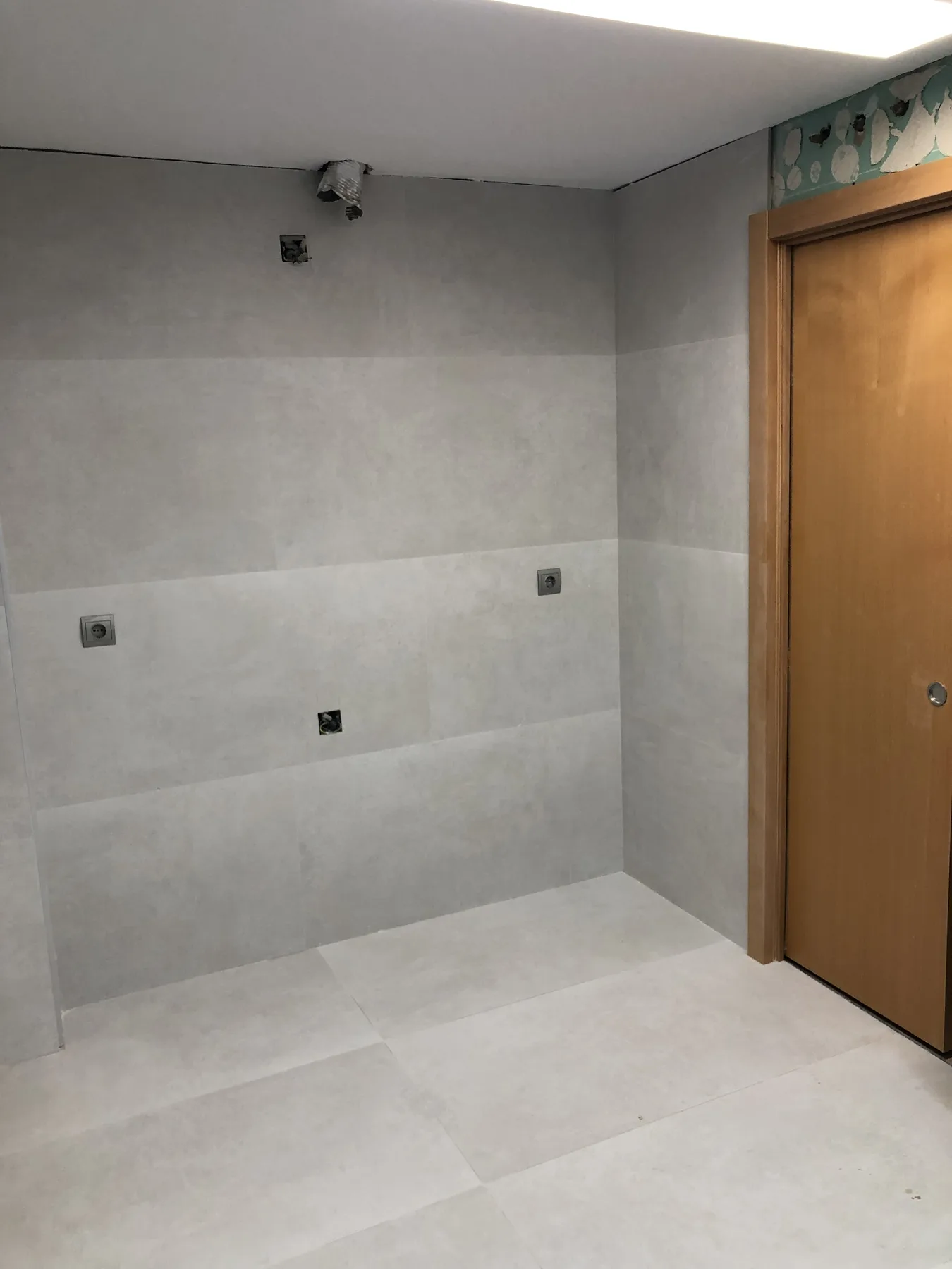 Alicatado de gran formato en tonos grises en un baño reformado